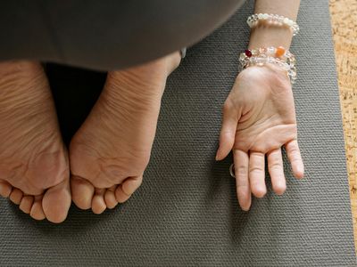 Close up of a hand resting on a yoga mat